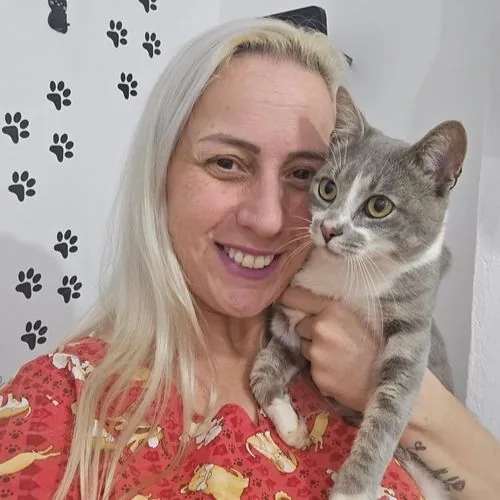 Dra. Cris sorrindo com um gato cinza no colo